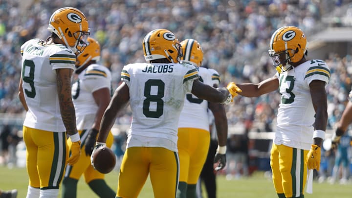 Green Bay Packers running back Josh Jacobs (8) and receiver Dontayvion Wicks (13) celebrate a touchdown against the Jaguars.
