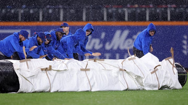 Sep 28, 2023; New York City, New York, USA; New York Mets grounds crew roll out the tarp during a