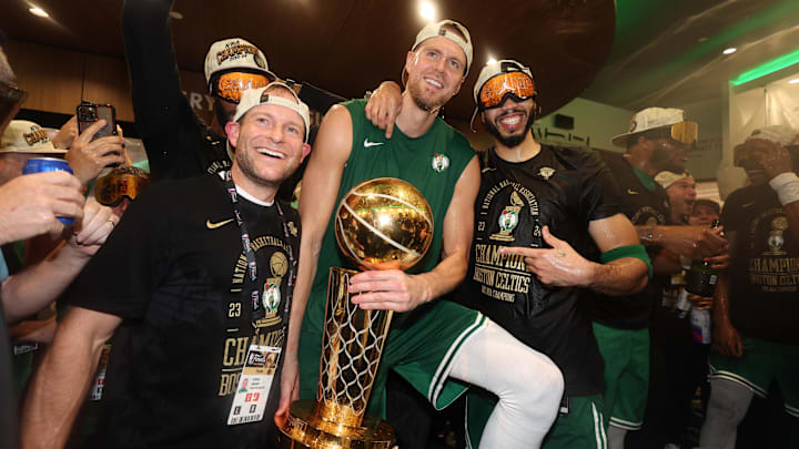 Jun 17, 2024; Boston, Massachusetts, USA; Boston Celtics center Kristaps Porzingis (center) and forward Jayson Tatum (right) celebrate with Celtics director of rehabilitation Steve Mount in the locker room after winning the 2024 NBA Finals against the Dallas Mavericks at TD Garden. Mandatory Credit: Elsa/Pool Photo-USA TODAY Sports