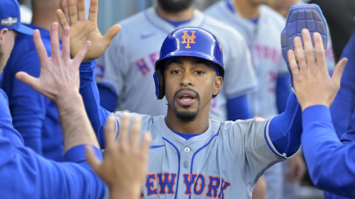 Oct 20, 2024; Los Angeles, California, USA; New York Mets shortstop Francisco Lindor (12) celebrates in the dugout after scoring in the first inning against the Los Angeles Dodgers during game six of the NLCS for the 2024 MLB playoffs at Dodger Stadium. Mandatory Credit: Jayne Kamin-Oncea-Imagn Images
