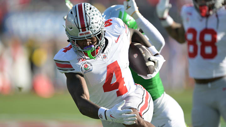 Jan 1, 2025; Pasadena, CA, USA; Ohio State Buckeyes wide receiver Jeremiah Smith (4) runs with the ball against the Oregon Ducks in the first quarter in the 2025 Rose Bowl college football quarterfinal game at Rose Bowl Stadium. Mandatory Credit: Jayne Kamin-Oncea-Imagn Images Jan 1, 2025; Pasadena, CA, USA; Ohio State Buckeyes wide receiver Jeremiah Smith (4) runs with the ball against the Oregon Ducks in the first quarter in the 2025 Rose Bowl college football quarterfinal game at Rose Bowl Stadium. Mandatory Credit: Jayne Kamin-Oncea-Imagn Images