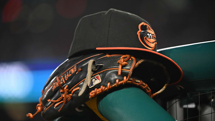 May 8, 2024; Washington, District of Columbia, USA; A Baltimore Orioles hat and glove rest on the dugout rail during a game against the Washington Nationals at Nationals Park. Mandatory Credit: Rafael Suanes-Imagn Images