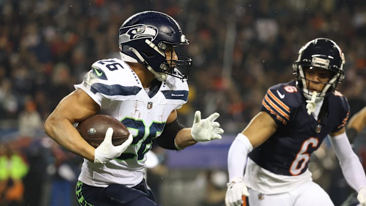 Dec 26, 2024; Chicago, Illinois, USA; Seattle Seahawks running back Zach Charbonnet (26) runs for a gain as Chicago Bears cornerback Kyler Gordon (6) defends during the first quarter at Soldier Field. Mandatory Credit: Talia Sprague-Imagn Images