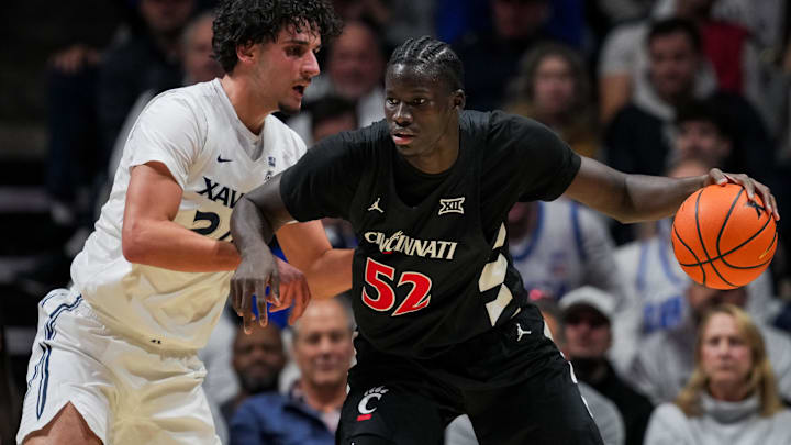 Dec 5, 2025; Cincinnati, Ohio, USA;  Cincinnati Bearcats center Moustapha Thiam (52) dribbles the ball against Xavier Musketeers forward Jovan Milicevic (24) in the first half at the Cintas Center. Mandatory Credit: Aaron Doster-Imagn Images
