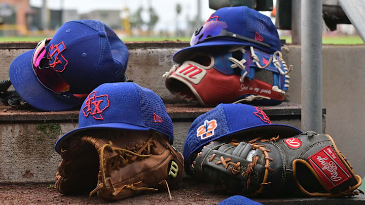 Mar 22, 2023; Scottsdale, Arizona, USA; A detail view of Texas Rangers hats and gloves during a Spring Training game against the San Francisco Giants at Scottsdale Stadium. 