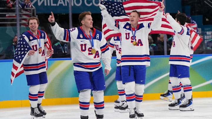 Feb 22, 2026; Milan, Italy;  United States players including Brady Tkachuk (7) of the United States celebrate after defeating Canada in the men's ice hockey gold medal game during the Milano Cortina 2026 Olympic Winter Games at Milano Santagiulia Ice Hockey Arena. Mandatory Credit: Amber Searls-Imagn Images