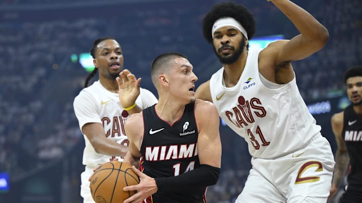 Apr 23, 2025; Cleveland, Ohio, USA; Miami Heat guard Tyler Herro (14) dribbles between Cleveland Cavaliers guard Darius Garland (10) and center Jarrett Allen (31) in the first quarter of game two of the first round of the 2025 NBA Playoffs at Rocket Arena. Mandatory Credit: David Richard-Imagn Images