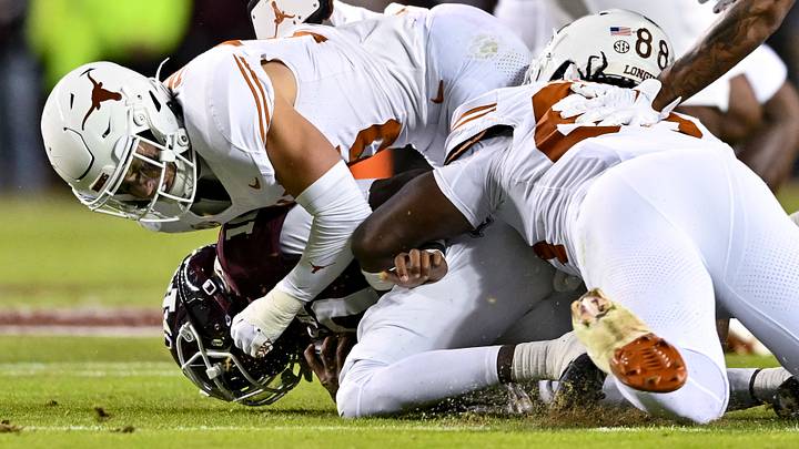 Nov 30, 2024; College Station, Texas, USA; Texas A&M Aggies quarterback Marcel Reed is tackled by Texas Longhorns defensive back Michael Taaffe and linebacker Barryn Sorrell Nov 30, 2024; College Station, Texas, USA; Texas A&M Aggies quarterback Marcel Reed is tackled by Texas Longhorns defensive back Michael Taaffe and linebacker Barryn Sorrell