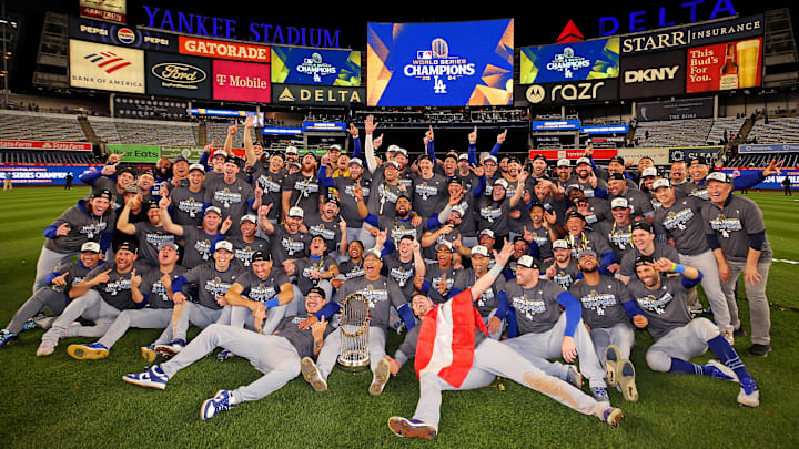 Oct 31, 2024; New York, New York, USA; The Los Angeles Dodgers pose for a picture with the Commissioner’s Trophy after beating the New York Yankees in game four to win the 2024 MLB World Series at Yankee Stadium. Mandatory Credit: Brad Penner-Imagn Images
