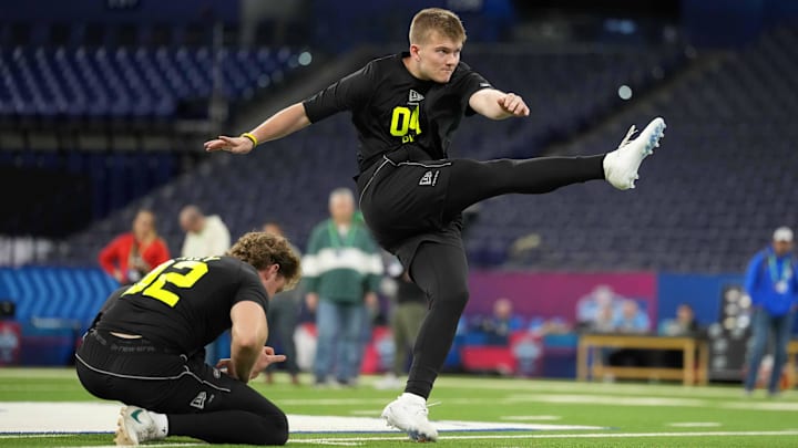 Feb 25, 2026; Indianapolis, IN, USA; Iowa place kicker Drew Stevens (PK04) kicks the ball out of the hold of Ryan Eckley of Michigan State during the NFL Scouting Combine at Lucas Oil Stadium. Mandatory Credit: Kirby Lee-Imagn Images