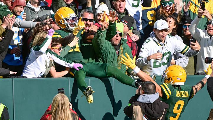 Nov 19, 2023; Green Bay, Wisconsin, USA;  Green Bay Packers wide receiver Jayden Reed (11) celebrates with wide receiver Christian Watson (9) and fans after scoring a touchdown in the first quarter against the Los Angeles Chargers at Lambeau Field. Mandatory Credit: Benny Sieu-Imagn Images