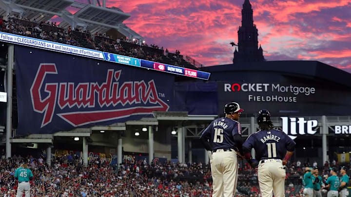 Cleveland Guardians first base coach Sandy Alomar Jr. (15) chats with Jose Ramirez as the sun sets during a game against the Seattle Mariners on June 18, 2024, in Cleveland, Ohio.