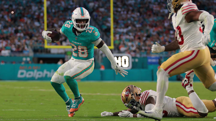 Miami Dolphins running back De'Von Achane (28) runs with the football past San Francisco 49ers linebacker Demetrius Flannigan-Fowles (45) during the second quarter at Hard Rock Stadium. Miami Dolphins running back De'Von Achane (28) runs with the football past San Francisco 49ers linebacker Demetrius Flannigan-Fowles (45) during the second quarter at Hard Rock Stadium.