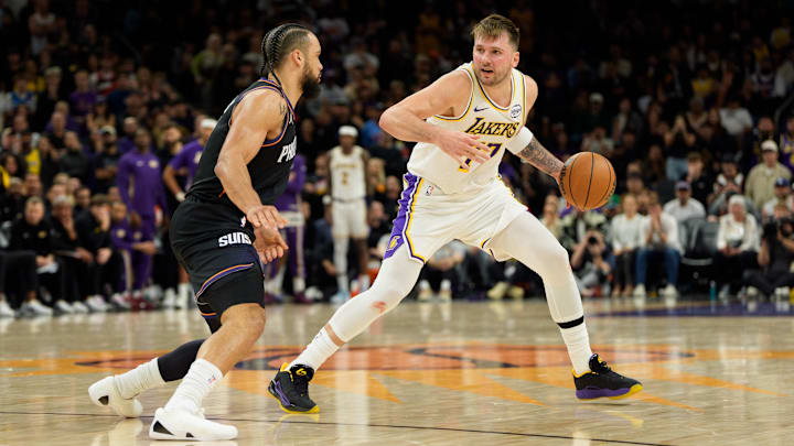 Dec 14, 2025; Phoenix, Arizona, USA; Los Angeles Lakers guard Luka Doncic (77) dribbles the ball as Phoenix Suns forward Dillon Brooks (3) defends during the second half of play at Mortgage Matchup Center. Mandatory Credit: Allan Henry-Imagn Images