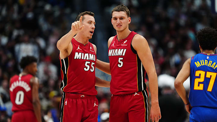 Nov 8, 2024; Denver, Colorado, USA; Miami Heat forward Duncan Robinson (55) and Miami Heat forward Nikola Jovic (5) talk in the fourth quarrel against the Denver Nuggets at Ball Arena. Mandatory Credit: Ron Chenoy-Imagn Images