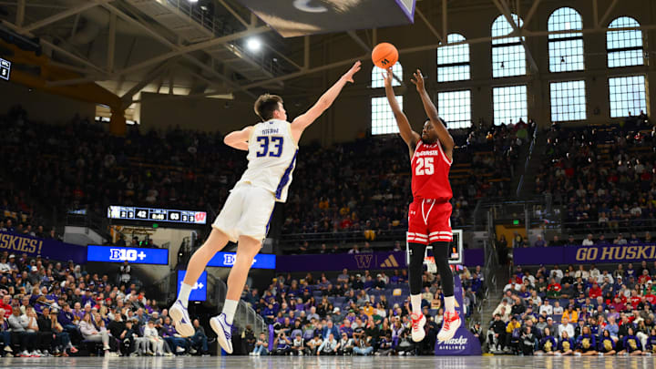 Feb 28, 2026; Seattle, Washington, USA; Wisconsin Badgers guard John Blackwell (25) shoots a three point shot over Washington Huskies forward Nikola Dzepina (33).