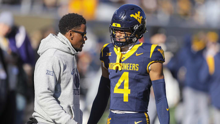 Nov 29, 2025; Morgantown, West Virginia, USA; West Virginia Mountaineers wide receiver Cam Vaughn (4) talks to West Virginia Mountaineers assistant coach Pat White during warmups prior to their game against the Texas Tech Red Raiders at Milan Puskar Stadium. Mandatory Credit: Ben Queen-Imagn Images