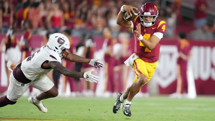 Aug 30, 2025; Los Angeles, California, USA; Southern California Trojans quarterback Husan Longstreet (4) carries the ball against Missouri State Bears cornerback Navonn Barrett (5) in the second half at United Airlines Field at Los Angeles Memorial Coliseum. Mandatory Credit: Kirby Lee-Imagn Images