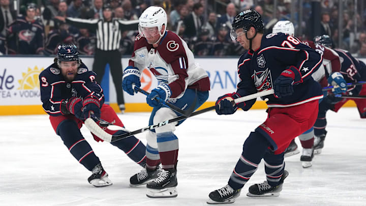 Blue Jackets defensemen Ivan Provorov and Damon Severson compete for the puck against Colorado.