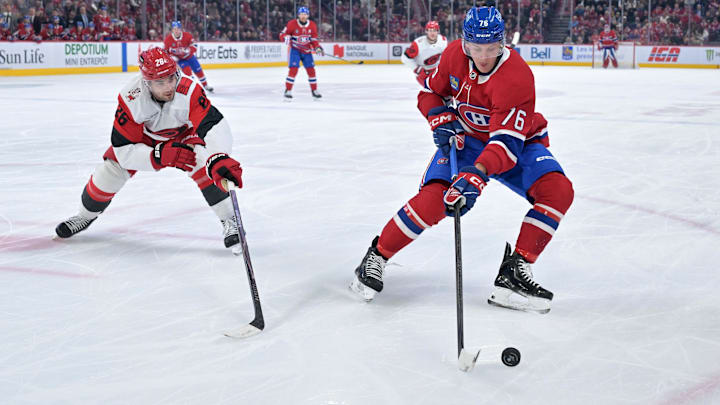 Mar 24, 2026; Montreal, Quebec, CAN; Montreal Canadiens forward Zack Bolduc (76) plays the puck and Carolina Hurricanes defenseman Sean Walker (26) defends during the first period at the Bell Centre. Mandatory Credit: Eric Bolte-Imagn Images