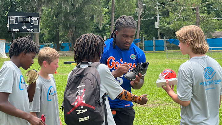 Florida Gators linebacker Myles Graham signs an autograph for campers
