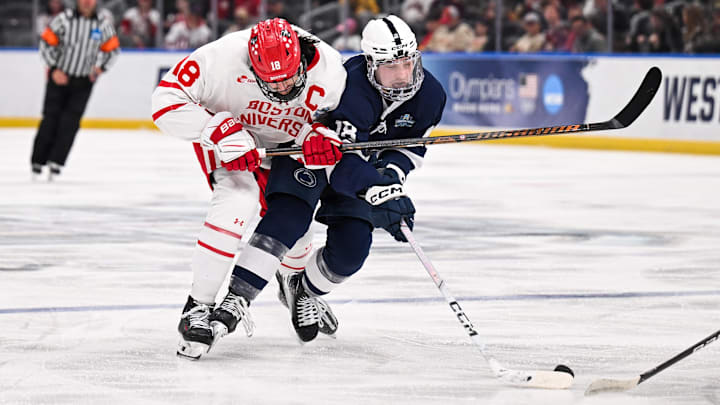 Boston University men's hockey forward Shane Lachance (18) and Penn State men's hockey forward Aiden Fink (18) collide while battling for the puck during the second of the Frozen Four semifinals