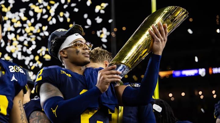 Jan 8, 2024; Houston, TX, USA; Michigan Wolverines defensive back Will Johnson (2) celebrates with the championship trophy after defeating the Washington Huskies during the 2024 College Football Playoff national championship game at NRG Stadium. Mandatory Credit: Mark J. Rebilas-Imagn Images