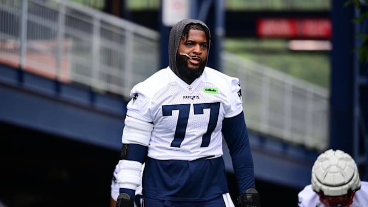 Jul 24, 2024; Foxborough, MA, USA; New England Patriots offensive tackle Chukwuma Okorafor (77) walks to the practice field during training camp at Gillette Stadium. Mandatory Credit: Eric Canha-Imagn Images