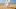 Young woman hiding behind bath towel on beach