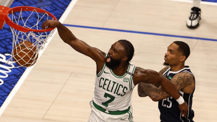 Jun 12, 2024; Dallas, Texas, USA; Boston Celtics guard Jaylen Brown (7) dunks against Dallas Mavericks forward P.J. Washington (25) and guard Josh Green (8) during the third quarter in game three of the 2024 NBA Finals at American Airlines Center. Mandatory Credit: Peter Casey-USA TODAY Sports