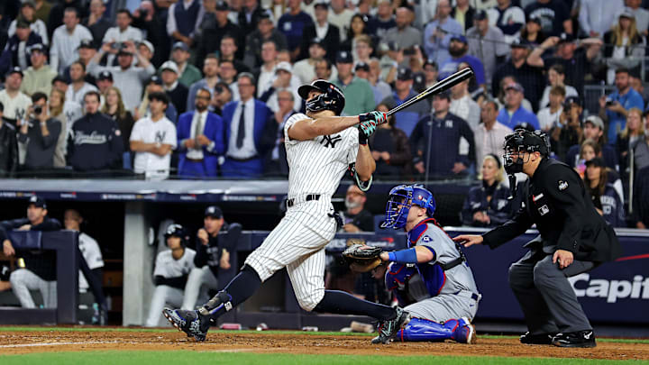 Oct 30, 2024; New York, New York, USA; New York Yankees designated hitter Giancarlo Stanton (27) hits an RBI sacrifice fly during the sixth inning against the Los Angeles Dodgers in game four of the 2024 MLB World Series at Yankee Stadium. 