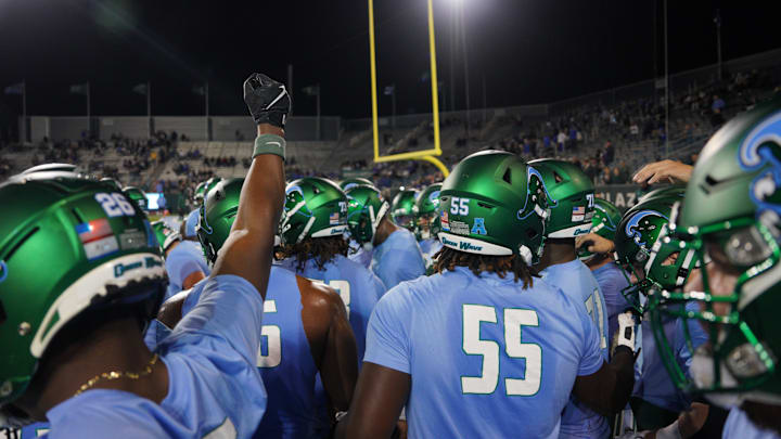 Tulane Green Wave players come together on the field before a game.