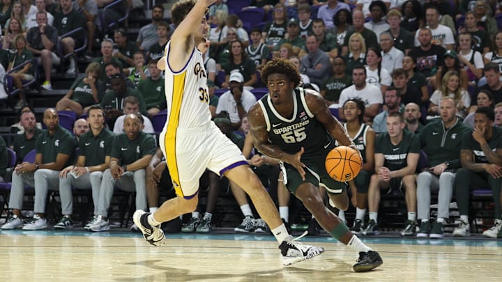 Nov 25, 2025; Fort Myers, Florida, USA; Michigan State Spartans forward Coen Carr (55) drives to the basket past East Carolina Pirates forward Eli Delaurier (33) in the second half at Suncoast Credit Union Arena. Mandatory Credit: Nathan Ray Seebeck-Imagn Images