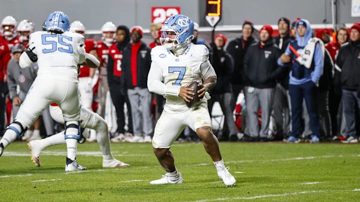 Nov 29, 2025; Raleigh, North Carolina, USA;  North Carolina Tar Heels quarterback Gio Lopez (7) runs with the football during the first half of the game against NC State Wolfpack at Carter-Finley Stadium.  Mandatory Credit: Jaylynn Nash-Imagn Images