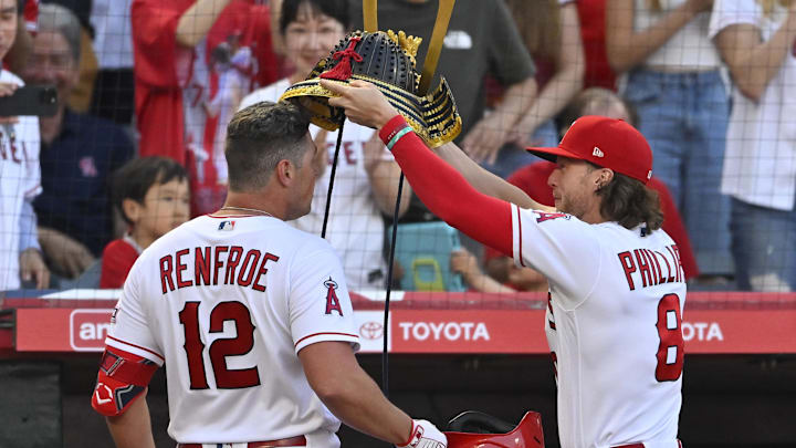 Apr 22, 2023; Anaheim, California, USA;  Los Angeles Angels center fielder Brett Phillips (8) places a samurai warrior hat on right fielder Hunter Renfroe (12) as Renfroe reaches the dugout after hitting a solo home run against the Kansas City Royals in the fourth inning at Angel Stadium. 