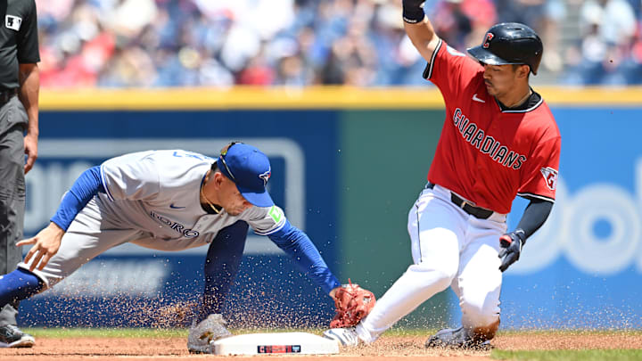 Jun 26, 2025; Cleveland, Ohio, USA; Cleveland Guardians left fielder Steven Kwan (38) slides into second with a double as Toronto Blue Jays second baseman Andres Gimenez (0) is late with the tag during the first inning at Progressive Field.