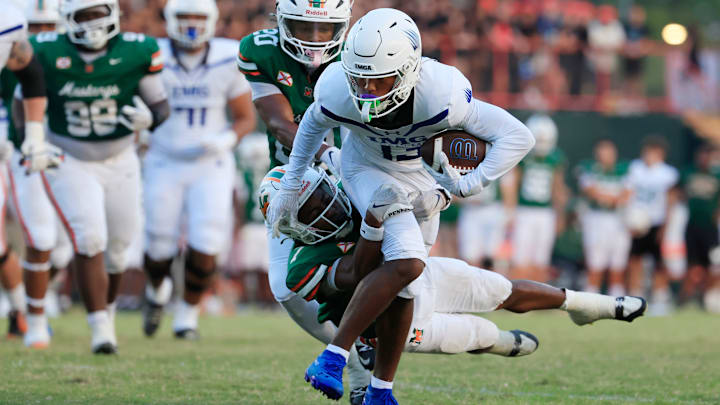 IMG Academy's Osani Gayles (13) rushes for yards against Mandarin's Tamajh Mitchell (7) during the first quarter of a high school football matchup at Mandarin High School, Friday, Sept. 19, 2025, in Jacksonville, Fla. The IMG Academy Ascenders defeated the Mandarin Mustangs 57-7.