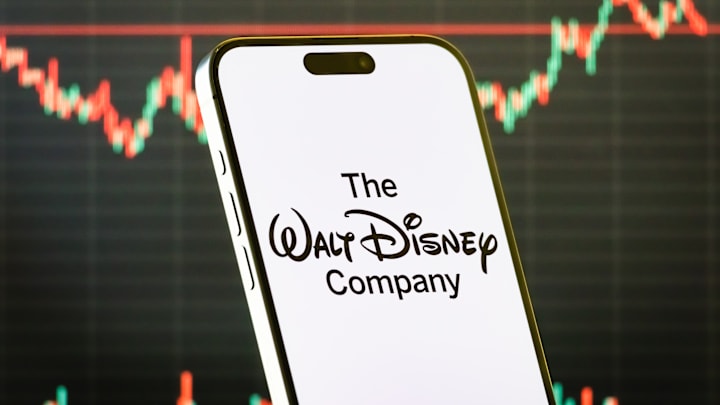 The Walt Disney Company logo on smartphone with stock market chart background