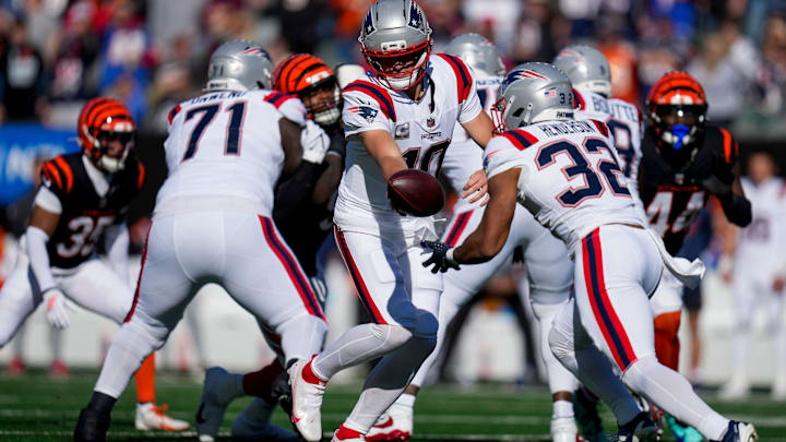 New England Patriots quarterback Drake Maye (10) hands off to running back TreVeyon Henderson (32) in the first quarter of the NFL Week 12 game between the Cincinnati Bengals and the New England Patriots at Paycor Stadium in downtown Cincinnati on Sunday, Nov. 23, 2025. New England Patriots quarterback Drake Maye (10) hands off to running back TreVeyon Henderson (32) in the first quarter of the NFL Week 12 game between the Cincinnati Bengals and the New England Patriots at Paycor Stadium in downtown Cincinnati on Sunday, Nov. 23, 2025.
