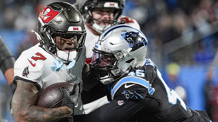 Dec 1, 2024; Charlotte, North Carolina, USA; Tampa Bay Buccaneers running back Bucky Irving (7) is tackled by Carolina Panthers linebacker Cam Gill (45) during the second half at Bank of America Stadium. Mandatory Credit: Jim Dedmon-Imagn Images