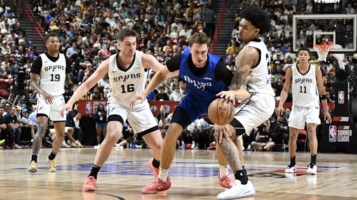 Jul 12, 2025; Las Vegas, NV, USA; Dallas Mavericks forward Cooper Flagg (32) dribbles against San Antonio Spurs guard Kyle Mangas (16) and guard Dylan Harper (2) in the second quarter of their game at Thomas & Mack Center. Jul 12, 2025; Las Vegas, NV, USA; Dallas Mavericks forward Cooper Flagg (32) dribbles against San Antonio Spurs guard Kyle Mangas (16) and guard Dylan Harper (2) in the second quarter of their game at Thomas & Mack Center.