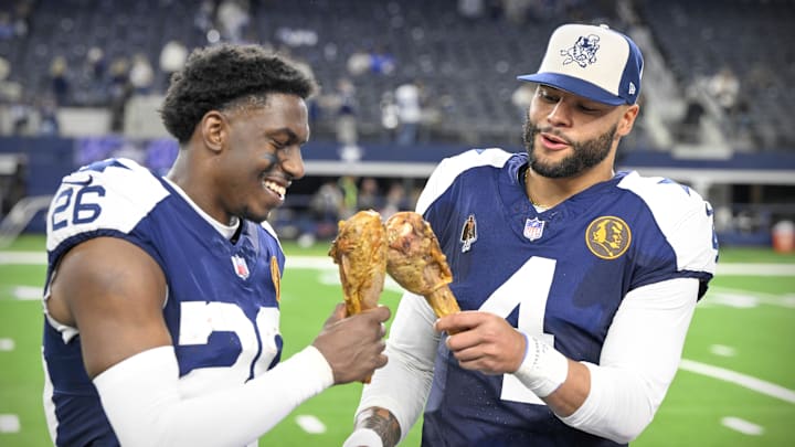 Dallas Cowboys cornerback DaRon Bland and quarterback Dak Prescott eat turkey legs after a Thanksgiving win over the Washington Commanders 