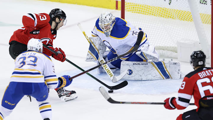 Feb 23, 2021; Newark, New Jersey, USA; New Jersey Devils center Nico Hischier (13) skates with the puck toward Buffalo Sabres goaltender Linus Ullmark (35) during the second period at Prudential Center. Mandatory Credit: Vincent Carchietta-Imagn Images