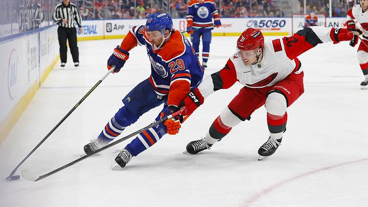 Mar 6, 2026; Edmonton, Alberta, CAN; Edmonton Oilers forward Leon Draisaitl (29) protects the puck from Carolina Hurricanes defensemen Alexander Nikishin (21) during the third period at Rogers Place. Mandatory Credit: Perry Nelson-Imagn Images