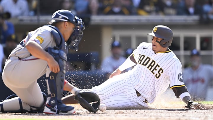 Mar 27, 2025; San Diego, California, USA; San Diego Padres third baseman Manny Machado (13) scores ahead of the throw to Atlanta Braves catcher Drake Baldwin (30)  during the seventh inning of a baseball game  at Petco Park. Mandatory Credit: Denis Poroy-Imagn Images