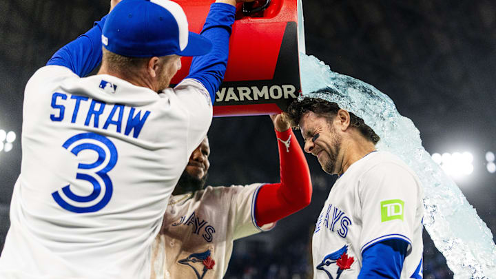 Toronto Blue Jays first baseman Vladimir Guerrero Jr. (27) and center fielder Myles Straw (3) pour a sports drink on third baseman Ernie Clement (22) after defeating the Athletics at Rogers Centre. 