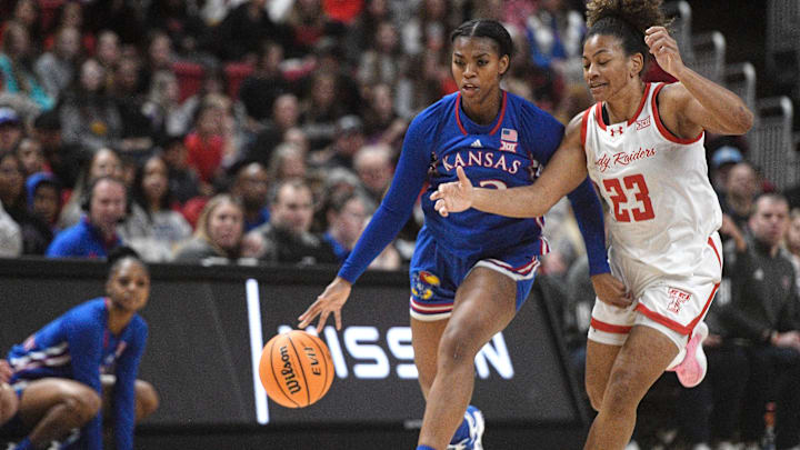 Kansas' guard S'Mya Nichols (12) dribbles while Texas Tech's guard Loghan Johnson (23) guards