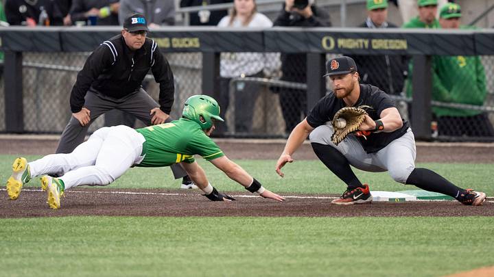 Oregon infielder Ryan Cooney dives safely back to first under cover from Oregon State infielder Jacob Krieg as the Oregon Ducks host the Oregon State Beavers on April 25, 2025, at PK Park in Eugene. Oregon infielder Ryan Cooney dives safely back to first under cover from Oregon State infielder Jacob Krieg as the Oregon Ducks host the Oregon State Beavers on April 25, 2025, at PK Park in Eugene.