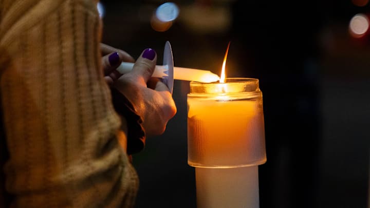 Attendees light small candles from the flame of the paschal candle to carry on the walk from Trinity Episcopal Cathedral to ASU's downtown campus in Phoenix on Nov. 20, 2023.