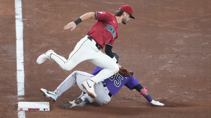 Aug 10, 2025; Phoenix, Arizona, USA; Arizona Diamondbacks shortstop Blaze Alexander (9) tags out Colorado Rockies outfielder Yanquiel Fernández (35) at third base during the sixth inning at Chase Field. Mandatory Credit: Joe Camporeale-Imagn Images